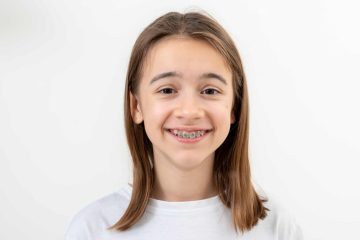 Teen wearing metal braces smiling confidently