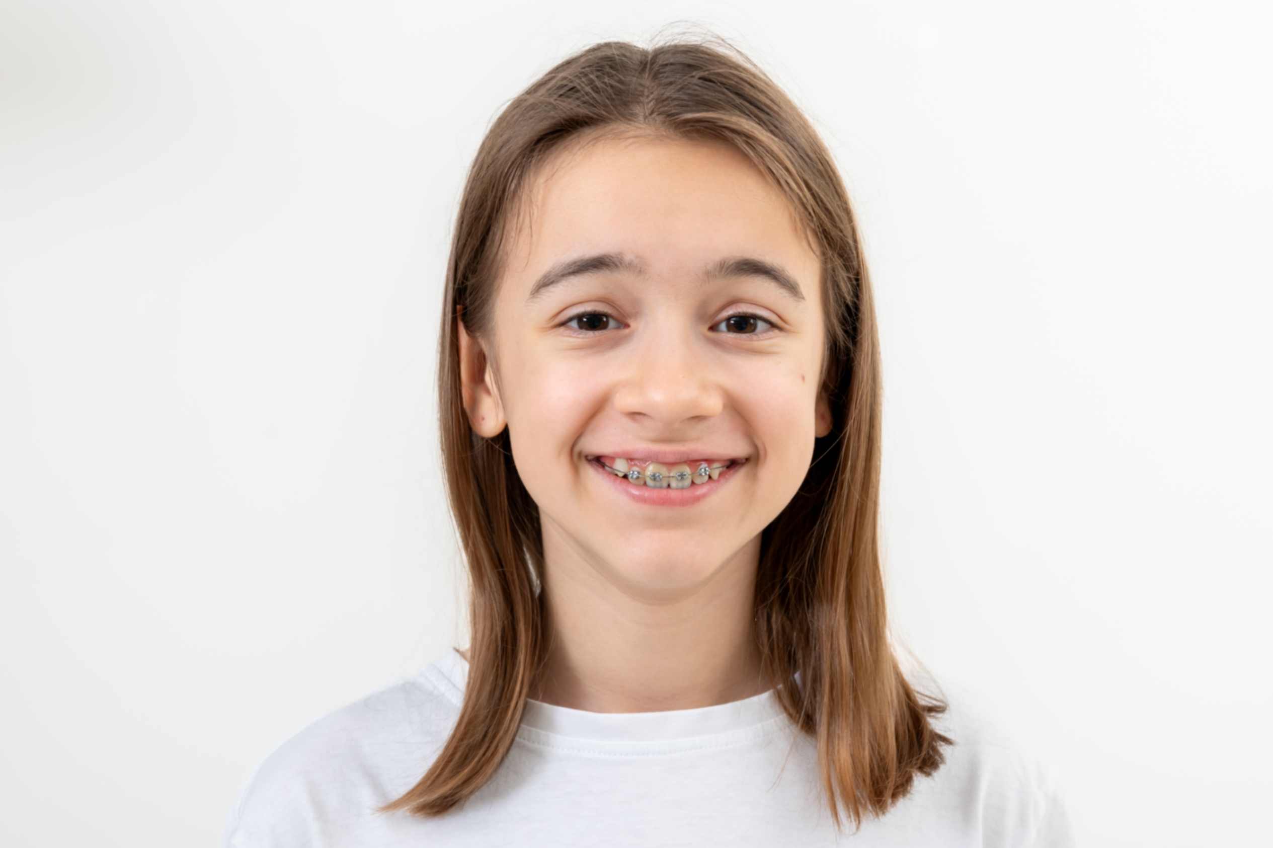 Teen wearing metal braces smiling confidently
